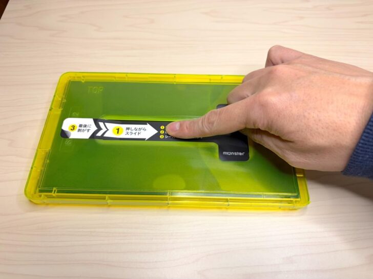 溝のところを軽く指で押しつつスライドしフィルムを吸着させる